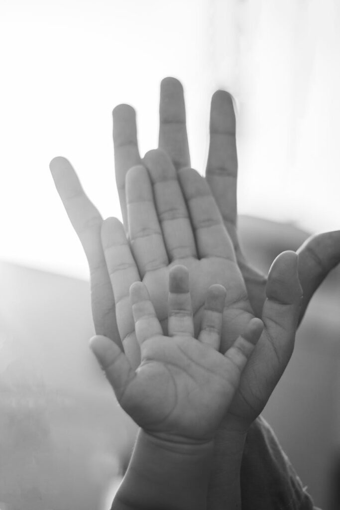 close up of parents and child palms together