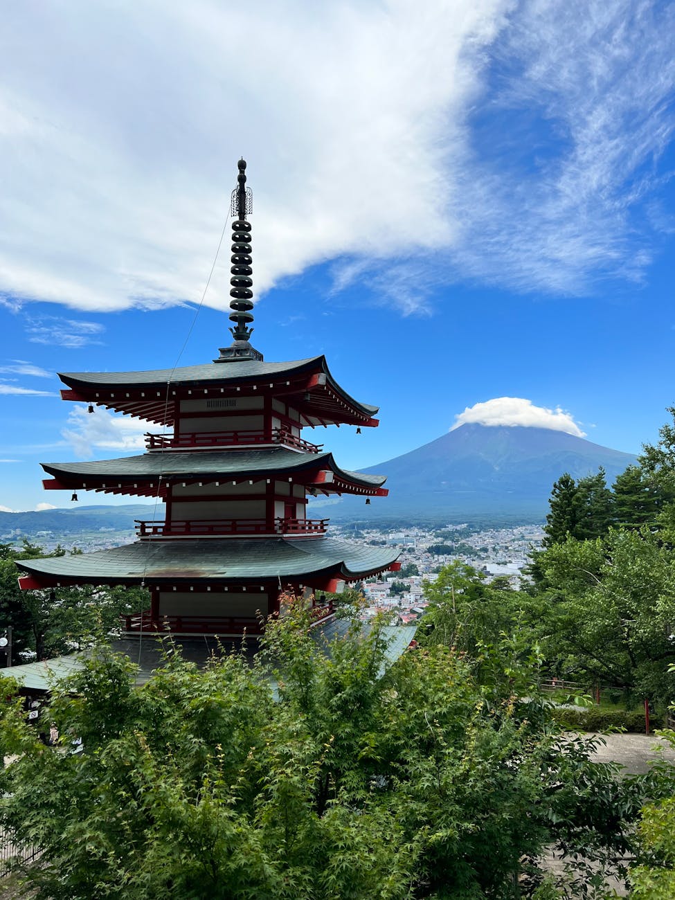 a pagoda in the middle of a forest with a mountain in the background